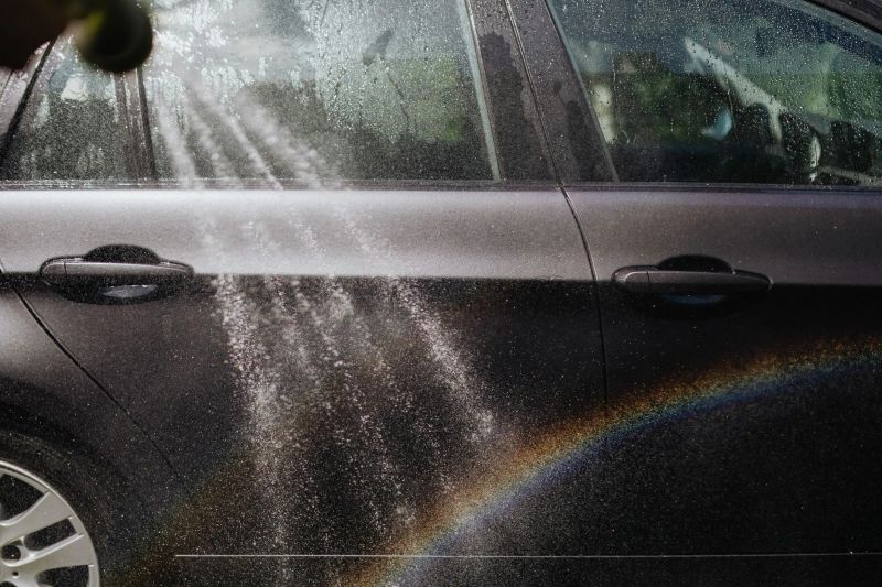 Window cleaning professional using a squeegee on residential glass